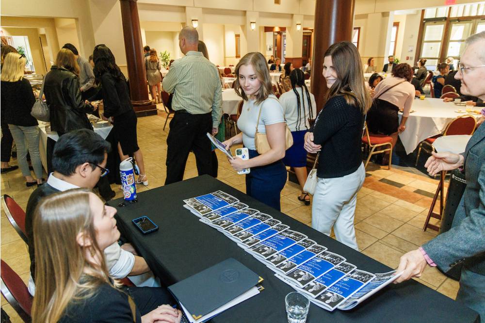 Guests entering the reception and grabbing programs